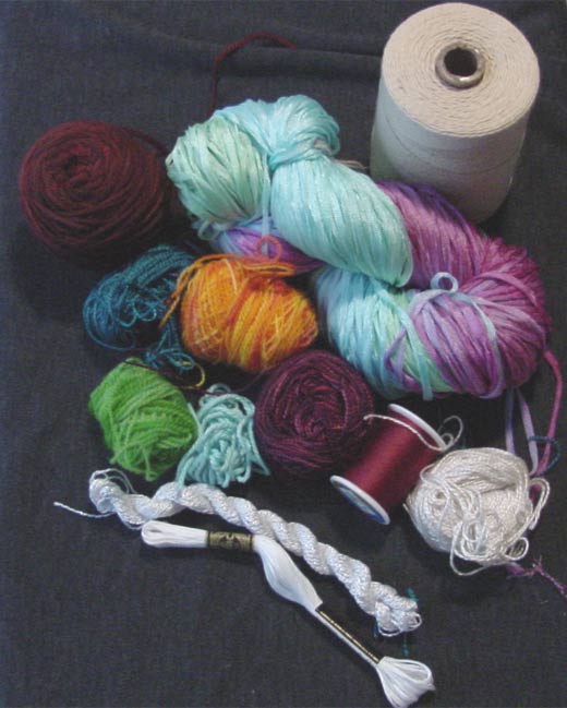 An assortment of string, yarns, and threads, including wool sock yarn, cotton twine, sewing thread, and embroidery floss.